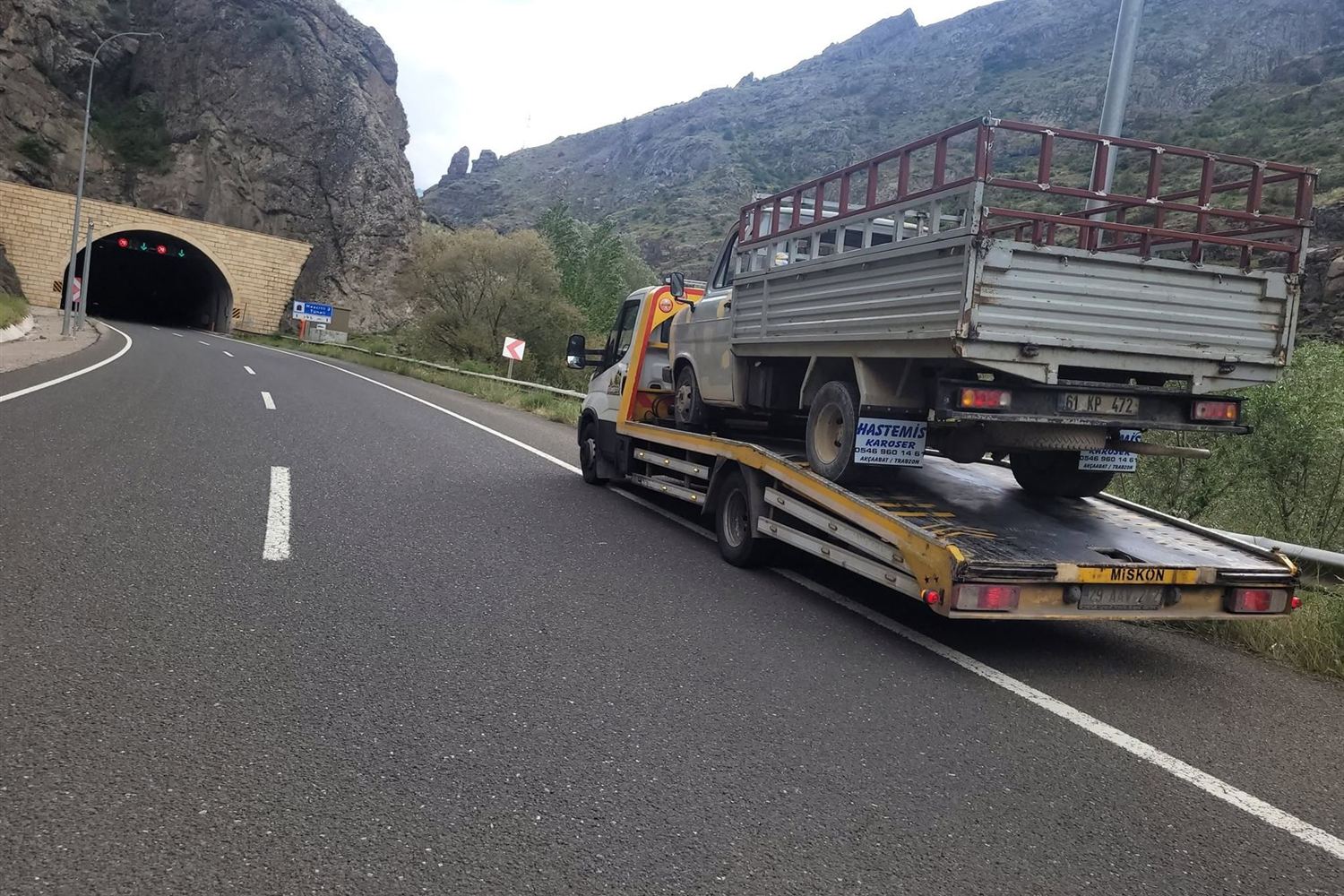 Tünel çıkışında dağ yolunda kamyonet taşıyan kayar kasalı çekici